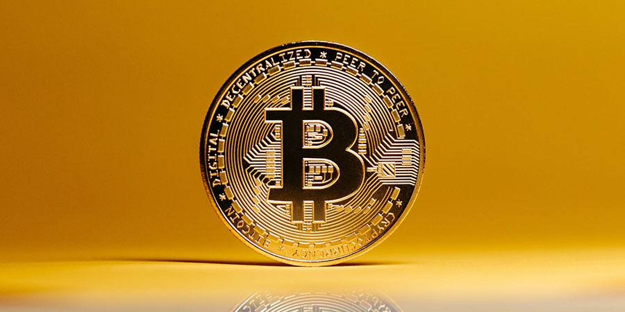 a gold bitcoin and a yellow background